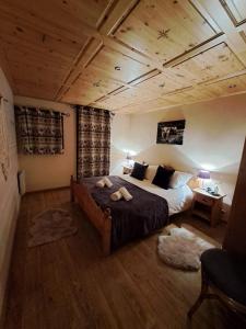沙泰勒的住宿－Chalet de montagne style savoyard, vue sur pistes，一间卧室设有一张大床和木制天花板