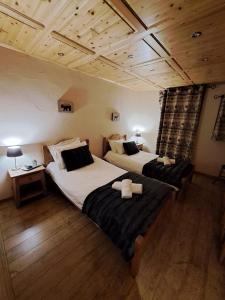 two beds in a room with wooden floors at Chalet de montagne style savoyard, vue sur pistes in Châtel