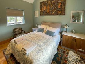 a bedroom with a large bed and a window at Le Jardin in Rodmarton