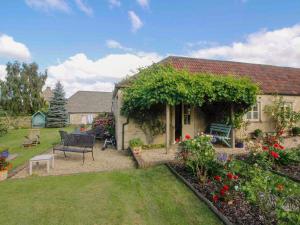 a house with a garden with flowers and plants at Le Jardin in Rodmarton