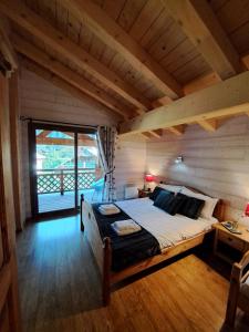 沙泰勒的住宿－Chalet de montagne style savoyard, vue sur pistes，一间带一张大床的卧室,位于带窗户的房间内