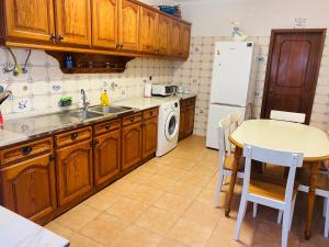 a kitchen with wooden cabinets and a sink and a table at SwordFish Beach House in Peniche
