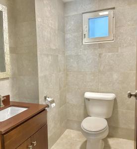 een badkamer met een toilet en een tv aan de muur bij OASIS 1 Bedroom Apartment Simpson Bay in Simpson Bay