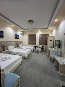 Habitación grande con varias camas y mesas. en Amina hotel, en Samarkand
