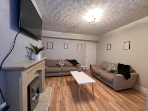 a living room with a couch and a fireplace at ST Nic House in Carlisle