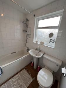 ein Badezimmer mit einem Waschbecken, einem WC und einer Badewanne in der Unterkunft ST Nic House in Carlisle