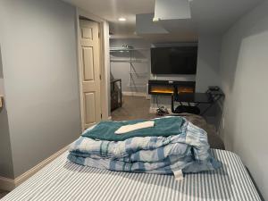 a bedroom with a bed and a flat screen tv at Downtown Suite - Close to Topgolf, Horseshoe Casino, UM Baltimore in Baltimore