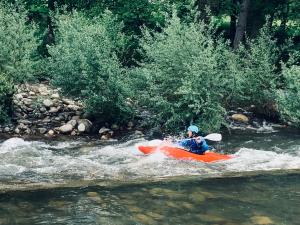 una persona está en un kayak en un río en Gites Libellule, en Aleu