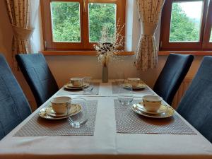 a dining room table with chairs and plates and glasses at Appartement Hartl in Filzmoos
