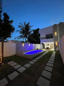 eine Villa mit einem Pool in der Nacht in der Unterkunft Casa com piscina em Coroa Vermelha in Santa Cruz Cabrália