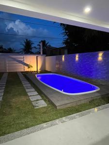 a swimming pool in a backyard at night at Casa com piscina em Coroa Vermelha in Santa Cruz Cabrália +5 photos