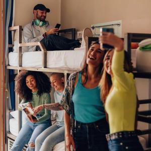 a group of people sitting on a bunk bed at Bposhtels Orlando Florida Mall in Orlando