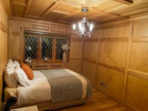 a bedroom with a bed and a chandelier at The GateHouse at Stansted in Hallingbury