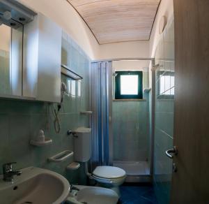 a bathroom with a sink and a toilet and a window at Villaggio Residence Pietra Grigia in Marina di Camerota