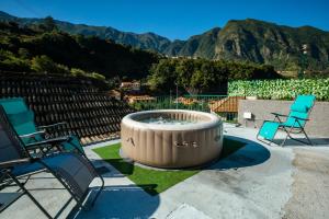 two chairs and a fire pit with mountains in the background at Stone House ''Vista'' By Atlantic Holiday in São Vicente