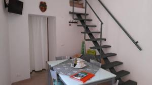 a room with a table and a spiral staircase at Zephyros - VIVERE IL MARE E LA STORIA DEL BORGO in Santa Caterina dello Ionio