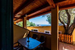 a table on the balcony of a house at Villaggio Residence Pietra Grigia in Marina di Camerota