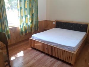 a bedroom with a bed and a window at Gazing Moon Homestay in Shamshi