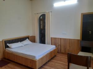 a bedroom with a bed and a chair in it at Gazing Moon Homestay in Shamshi