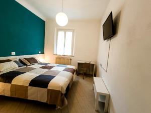 1 dormitorio con 1 cama y TV de pantalla plana en FirstHouse - nel centro storico con Parcheggio Gratuito, en Siena