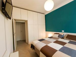 1 dormitorio con 1 cama y TV de pantalla plana en FirstHouse - nel centro storico con Parcheggio Gratuito, en Siena