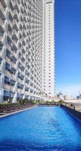 un gran edificio con piscina frente a un edificio en Penthouse unit at Coast Residences Walking to PICC/Star City, en Manila