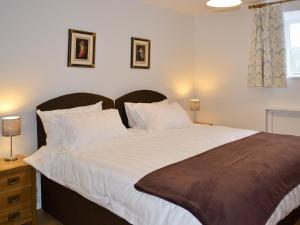 a bedroom with a large bed with white sheets and pillows at The Stalls - Nac in Aynho