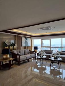 sala de estar con sofá, mesas y ventanas en Penthouse unit at Coast Residences Walking to PICC/Star City, en Manila