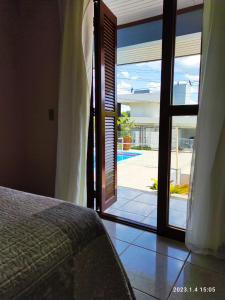 a bedroom with a door open to a patio at Quartos familiares com piscina in Encantado +12 photos