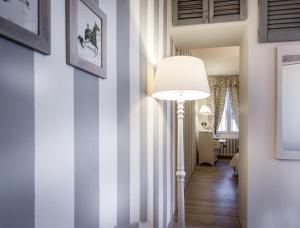 a hallway with a floor lamp and a striped wall at Como Unique View - byMyHomeinComo in Como