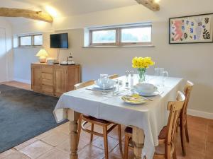une salle à manger avec une table et des chaises blanches dans l'établissement The Parlour, à Warbleton