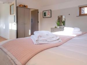 een slaapkamer met een bed met handdoeken erop bij The Parlour in Warbleton