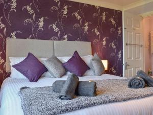 een slaapkamer met een groot bed met paarse muren bij The Orchard in Bideford