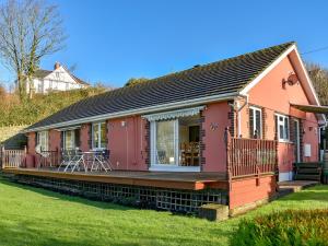 a pink house with a deck on the grass at The Orchard in Bideford