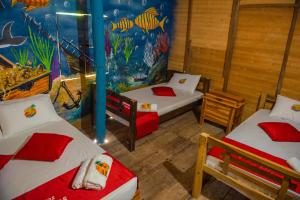 a room with two beds and a fish themed wall at Nuestros Tres Tesoros II in Playa Blanca