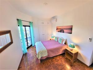a small bedroom with a bed and a window at Apartamento Praia Fuzeta 2 in Fuzeta