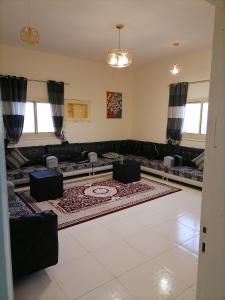 Khair Jewaar Apartments Al Madinah في المدينة المنورة: غرفة معيشة مع أريكة وسجادة
