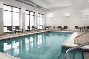 a swimming pool with chairs and tables in a building at Hyatt Place Pittsburgh North Shore in Pittsburgh