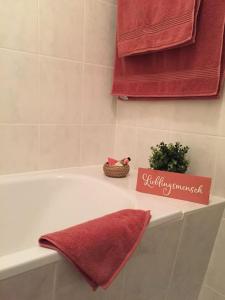 La salle de bains est pourvue d'une baignoire avec une serviette rouge. dans l'établissement Gründerzeitwohnung in beliebter Südvorstadt, à Leipzig