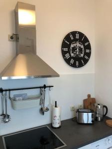 une horloge sur le mur au-dessus d'un comptoir de cuisine dans l'établissement Gründerzeitwohnung in beliebter Südvorstadt, à Leipzig