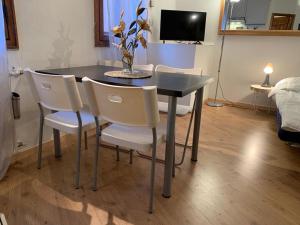 a dining room table with chairs and a vase of flowers on it at Piccolo Rifugio di Foppolo in Foppolo