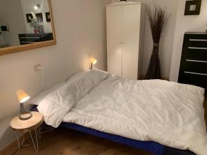 un letto con piumone bianco in una camera da letto di Piccolo Rifugio di Foppolo a Foppolo