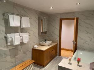 y baño con lavabo, ducha y bañera. en The GateHouse at Stansted, en Hallingbury