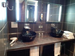 ein Badezimmer mit zwei Waschbecken und Spiegeln auf der Theke in der Unterkunft Logis Domaine de Peyrolade in Daux