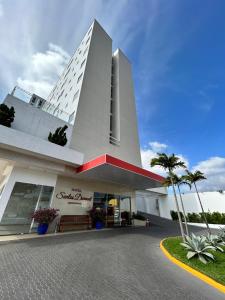duży biały budynek z ławką przed nim w obiekcie Hotel Santos Dumont Aeroporto SLZ w mieście São Luís