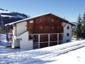 Un edificio en la nieve frente a un edificio cubierto de nieve. en Charmant studio avec terrasse et parking couvert - FR-1-505-49, en Notre-Dame-de-Bellecombe 12 fotos más