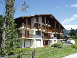 a large white building with balconies and a fence at Studio Notre-Dame-de-Bellecombe, 1 pièce, 4 personnes - FR-1-505-49 in Notre-Dame-de-Bellecombe