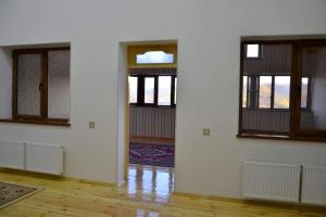 an empty room with white walls and windows at Seymur’s house in Quba