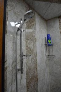 a shower with a shower head in a bathroom at Seymur’s house in Quba