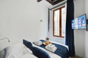 ein Schlafzimmer mit einem Bett mit Handtüchern und einem Fenster in der Unterkunft Lovely 2BR - Near La Sorbonne & Quartier Latin in Paris